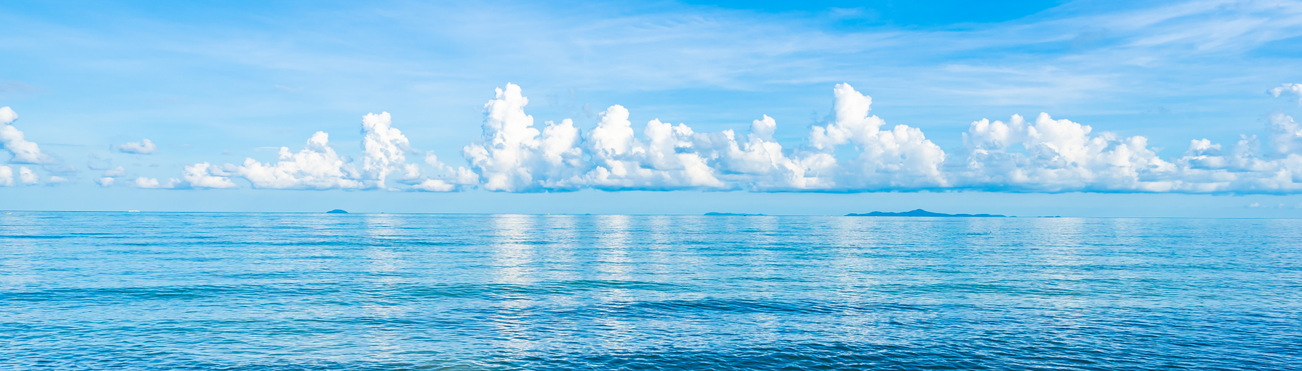 Beautiful tropical beach sea ocean with white cloud blue sky and copyspace for leisure travel in holiday vacation concept